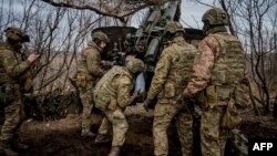 Ukrainian servicemen load a 152 mm shell into a Msta-B howitzer to fire toward Russian positions, near the frontline town of Bakhmut on March 2, 2023, during the Russian invasion of Ukraine.