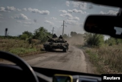 Ukrainian servicemen ride on a tank, as Russia's attacks on Ukraine continue, near the village of Robotyne, Zaporizhzhia region, Ukraine, Aug. 25, 2023.