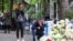 FILE - People react as they pay tribute the day after a school mass shooting when a boy opened fire, killing fellow students and staff in Belgrade, Serbia, May 4, 2023. 
