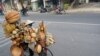 Seorang wanita mengendarai sepeda mengangkut barang-barang perabot rumah tangga dari bambu dan rotan untuk dijual di sebuah jalan di Hanoi, Vietnam. (AFP)