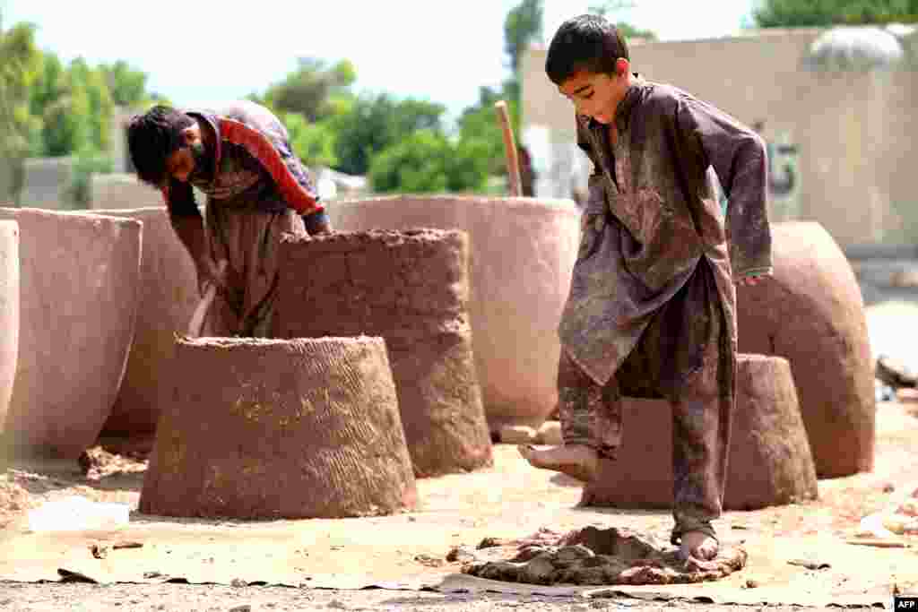 An Afghan boy and man work on clay ovens in Nangarhar province.