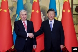 Presiden Kazakhstan Kassym-Jomart Tokayev, kiri, berjabat tangan dengan Presiden China Xi Jinping menjelang KTT China-Asia Tengah di Xi'an di Shaanxi China, 17 Mei 2023. (Foto: via AP)