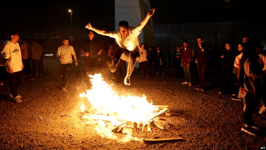 An Iranian jumps over a bonfire during the Wednesday Fire feast, or Chaharshanbeh Soori, held annually on the last Wednesday eve before the Spring holiday of Nowruz, in Tehran on March 14, 2023 ahead of the Nowruz New Year festival.