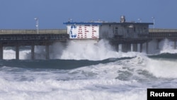 Grandes olas chocan contra un muelle del océano debido a los fuertes vientos en el barrio de Ocean Beach de San Diego, California en una muestra de la tormenta invernal que amenaza todo EEUU, el 22 de febrero de 2023.