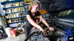 FILE - Elise Lacroix, pemilik bengkel Stop & Go di Brattleboro, Vt., mengganti oli kendaraan di bengkelnya, 15 Juli 2024. (Kristopher Radder/The Brattleboro Reformer via AP)