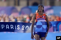 Sifan Hassan of the Netherlands celebrates after crossing the finish line to win the gold medal in the women's marathon at the 2024 Summer Olympics, Aug. 11, 2024, in Paris. Hassan, a native of Ethiopia, has won three gold medals for the Netherlands.