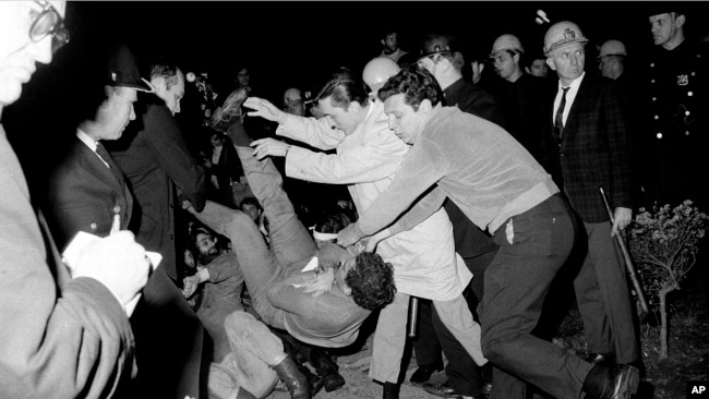 ARCHIVO - Policías vestidos de civil de la ciudad de Nueva York arrojan al suelo a un manifestante estudiantil después de que él y otros que realizaban una sentada en el edificio de la Universidad de Columbia fueron expulsados, el 30 de abril de 1968.