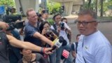 Hong Kong Journalists Association's Chairman Ronson Chan, right, speaks to reporters outside a court building in Hong Kong, Sept. 25, 2023. 