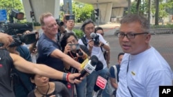 Hong Kong Journalists Association's Chairman Ronson Chan, right, speaks to reporters outside a court building in Hong Kong, Sept. 25, 2023. 