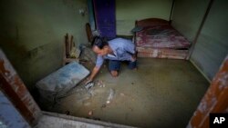 Ganga Ram Subba, searches for his documents in the mud inside his house in the flood affected area along the Teesta river in Rongpo, east Sikkim, India, Oct. 8. 2023. 