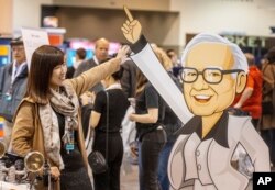 Hami Liu from Taiwan poses for a photo with a cardboard cutout of Warren Buffett at the See's Candies booth during the Berkshire Bazaar of Bargains at the CHI Health Center, May 5, 2023.