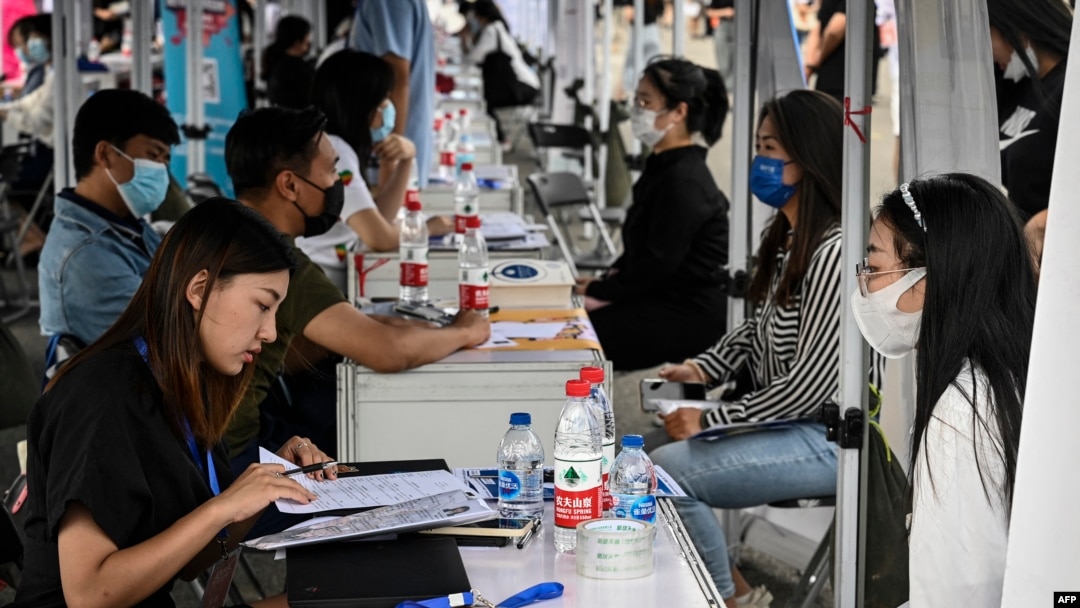 FILE -The photo taken on Aug. 26, 2022 shows young people attending a job fair in Beijing.