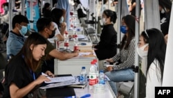 FILE -The photo taken on Aug. 26, 2022 shows young people attending a job fair in Beijing.
