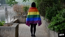 FILE - A gay student sports a rainbow flag in Beijing, May 10, 2019. The Beijing LGBT Center, one of China's leading organizations providing resources and support for the queer population, announced in May 2023 that it would cease operations.