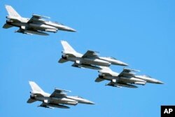 ARCHIVO - Aviones de combate F-16 de fabricación estadounidense vuelan en el cielo sobre la capital de Polonia mientras participan en un desfile militar masivo para celebrar el Día del Ejército Polaco, en Varsovia, Polonia, el 15 de agosto de 2023.