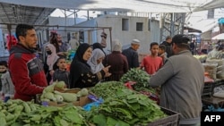 Palestinians shop at a market in Rafah in the southern Gaza Strip on May 14, 2023, 
