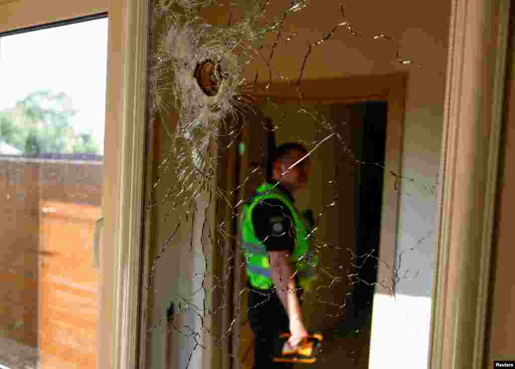 A police officer is reflected in a mirror on a wall of residential house damaged by part of a missile during Russian missile and drone strikes, amid Russia's attack on Ukraine, in Kyiv, Ukraine.