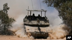 Israeli soldiers drive a tank near the Israeli-Gaza border, in southern Israel, May 29, 2024.
