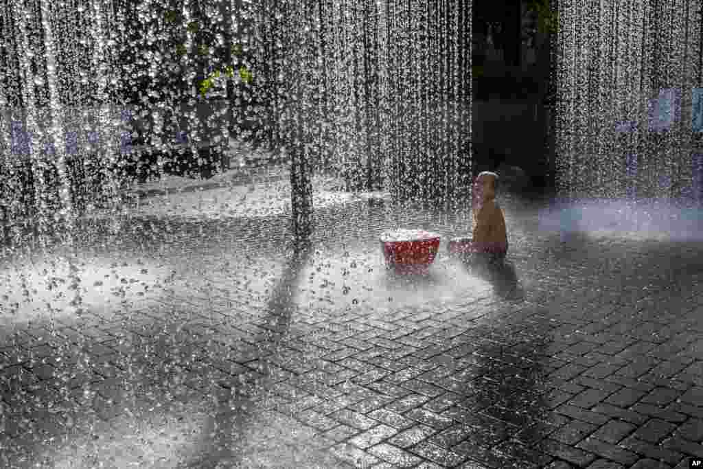 A boy cools off in a public fountain in Vilnius, Lithuania. The heat wave continues in Lithuania as temperatures rise to as high as 32 degrees Celsius (89.6 degrees Fahrenheit).