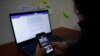 Xenia Oliva, reportera de investigación de Gato Encerrado, a quien le piratearon el teléfono siete veces, incluida la extracción de datos, revisa su teléfono en la oficina de su medio de prensa en San Salvador, El Salvador, el 11 de enero de 2022.
