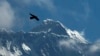 FILE - A bird flies against the backdrop of Mount Everest, as seen from Namche Bajar, Solukhumbu district, Nepal, May 27, 2019. A Kenyan climber attempting to scale the world’s highest mountain has been found dead near the summit.