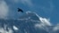FILE - A bird flies against the backdrop of Mount Everest, as seen from Namche Bajar, Solukhumbu district, Nepal, May 27, 2019. A Kenyan climber attempting to scale the world’s highest mountain has been found dead near the summit.