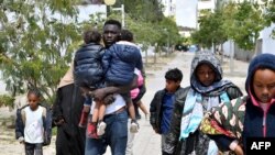 FILE: Migrants leave after Tunisian police dismantled a makeshift camp for refugees from sub-Saharan African countries in front of the U.N. High Commission for Refugees headquarters in Tunis, on April 11, 2023.