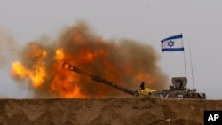 An Israeli mobile artillery unit fires a shell from southern Israel toward the Gaza Strip, in a position near the Israel-Gaza border, Dec. 21, 2023.