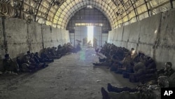 In this photo provided by the Ukrainian Security Service Press Office, over 100 Russian prisoners of war captured by a Security Service special unit during one military action are seen in a shelter in Kursk region, Russia, Aug. 14, 2024.