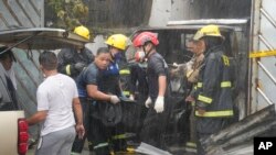 Petugas pemadam kebakaran membawa kantong jenazah korban kebakaran di kota Quezon, Filipina, Kamis, 31 Agustus 2023. (AP/Aaron Favila)