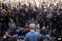Members of the media gather for a press conference by the negotiation team near a pro-Palestinian demonstration encampment at Columbia University, April 26, 2024, in New York.