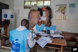 Electoral officials count and verify ballots inside a polling station in Goma, eastern Democratic Republic of the Congo, Dec. 21, 2023.