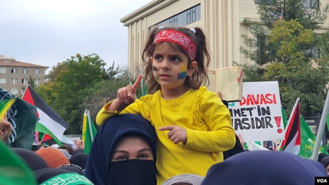 Küçük bir kız çoğunun yüzüne çizilen Filistin ve Ukrayna bayrakları dikkat çekti