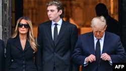 FILE - Barron Trump, center, stands with his mother, former first lady Melania Trump, left, and father, former U.S. President Donald Trump, at a funeral in Palm Beach, Florida, Jan. 18, 2024. On Friday, Barron Trump withdrew as a delegate to the 2024 Republican Party convention. 