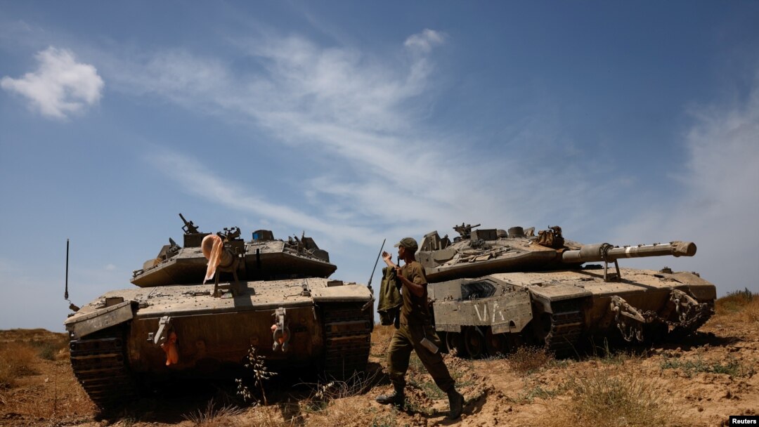 Seorang tentara Israel berjalan di samping tank yang berada di dekat perbatasan Israel-Jalur Gaza, pada 2 Mei 2024. (Foto: Reuters/Amir Cohen)