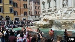 A photo taken and issued as a handout on May 21, 2023 by environmental activists shows banners reading 'we don't pay for the fossil' in historic Fontana di Trevi fountain, in Rome. (Photo by handout / Last Generation / AFP) 