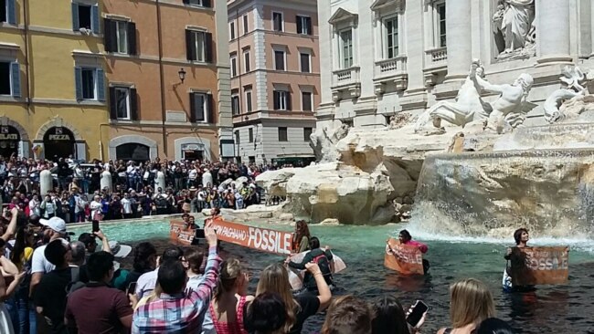 A photo taken and issued as a handout on May 21, 2023 by environmental activists shows banners reading 'we don't pay for the fossil' in historic Fontana di Trevi fountain, in Rome. (Photo by handout / Last Generation / AFP)