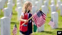 Devojčica nosi zastave na vojnom groblju u Tenesiju povodom Dana sećanja (AP Photo/George Walker IV)