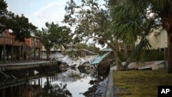 An unstilted home that was swept off its blocks by Hurricane Idalia lies in a canal between homes on stilts that survived, in Horseshoe Beach, Fla.,, Sept. 1, 2023, two days after the storm's passage. 
