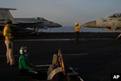 Fighter jets maneuver during take-off operations on the deck of the USS Dwight D. Eisenhower in the Red Sea, June 11, 2024.