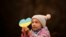 Seorang gadis kecil memegang guntingan berbentuk hati dengan warna bendera Ukraina, selama aksi protes menentang invasi Rusia di Ukraina, menandai peringatan pertama invasi besar-besaran Rusia ke Ukraina, di Bukares, Rumania.