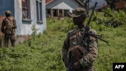 Un soldat du M23 monte la garde lors de la rencontre entre les responsables de la Force régionale de l'Afrique de l'Est et les rebelles du M23 au camp de Rumangabo, dans l'est de la République démocratique du Congo, le 6 janvier 2023.