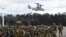 FILE - Tentara Filipina dan Australia berbaris dalam formasi, sementara helikopter marinir AS V-22 Osprey melayang di atas selama latihan militer Alon, di pangkalan angkatan laut kota San Antonio, provinsi Zambales, utara Manila, 25 Agustus 2023. (TED ALJIBE / AFP)