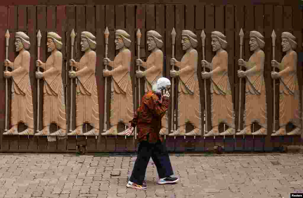 A devotee walks past a gate of a Parsi fire temple in Mumbai, India.