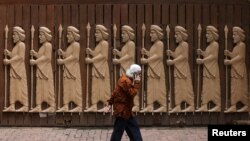 A devotee walks past a gate of a Parsi fire temple in Mumbai, India.