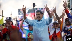 Venezuelan President Nicolas Maduro flashes victory hand signs at supporters during a pro-government rally, in Caracas, Venezuela, Aug. 17, 2024. 