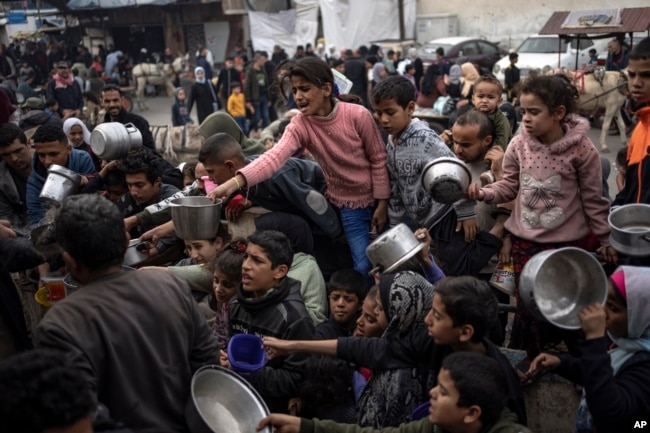 Orang-orang Palestina antre untuk mendapatkan bantuan pangan di Rafah, Jalur Gaza, 21 Desember 2023. (Foto: Fatima Shbair/AP Photo)