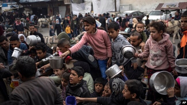 FILE - Palestinians line up for a free meal in Rafah, Gaza Strip, Dec. 21, 2023.