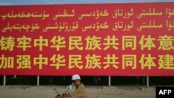 تابلۆیەک کە حکومەتی چین لە ناوچەیەکی هەرێمی شینجیانگی زۆرینە ئۆیغوور دایناوە، لەسەری نووسراوە"تێگەیشتنێکی کشتیمان هەبێت بۆ گەلی چین"