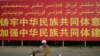 (FILE) A man riding a scooter past a government billboard urging people to 'forge an understanding of the collective Chinese people' in Xinjiang.